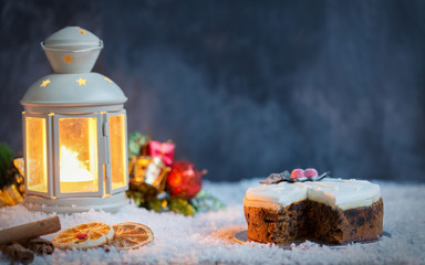 Cur Christmas Fruit Cake on snow with a lantern and decorations
