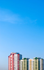 Tops of apartment houses against the blue sky