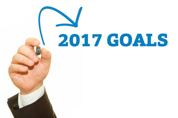 Businessman hand writing 2017 Goals on a transparent wipe board