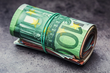 Euro banknotes. Euro currency. Euro money. Close-up Of A Rolled Euro Banknotes On concrete or...