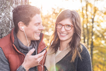 Junges verliebtes Paar teilt sich Kopfhörer zum Musikhören