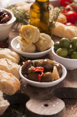 Bread, olives and artichokes served on a wooden table