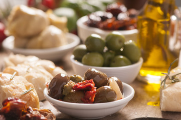Bread, olives and artichokes served on a wooden table