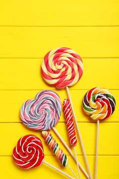 Sweet lollipops on a yellow wooden table