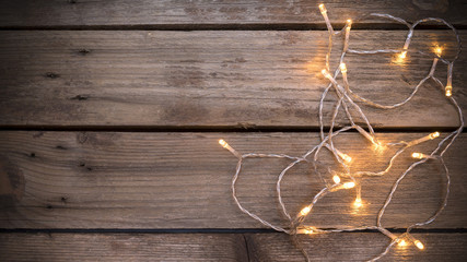 Christmas led lights on aged wooden bakground