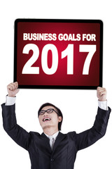 Businessman holding text and numbers on a board