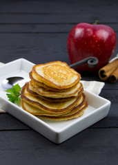Homemade pancakes with apple and cinnamon on the wooden table