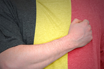 man's hand on the t-shirt with the national flag of belgium.