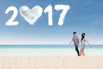 Fototapeta na wymiar Happy couple with 2017 on beach