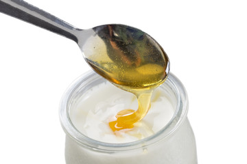 Yogurt and pouring honey on white background