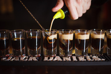 The bartender cocktail B 52 at the front