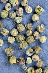 Group of green peppercorns on slate