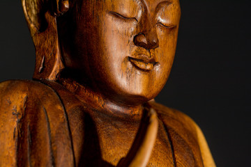 Fototapeta na wymiar Low Key Portraiture of wooden Budda Statue, Thailand