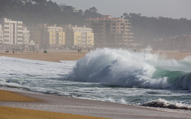 Ocean waves on beach in Nazare. Autumn day on the Atlantic coast in Portugal.
