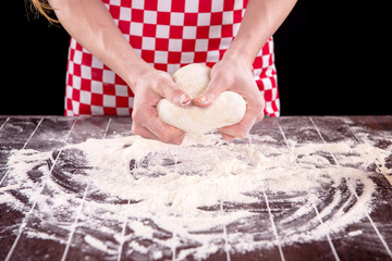 Cook preparing dough for baking in the kitchen