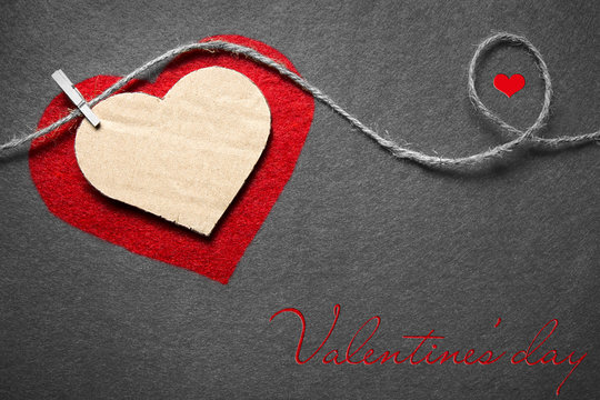 Black white red. Valentine's day. Two hearts from felt and cardboard on rope with clothespin on black and white background