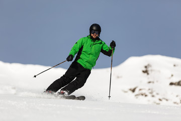 Male skier skiing on ski slope