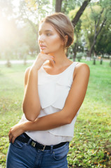 Fototapeta premium Bautiful girl wearing a white shirt poses in a city park