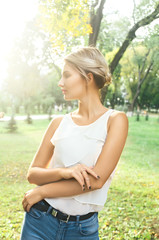 Fototapeta premium Bautiful girl wearing a white shirt poses in a city park