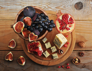 figs and black grapes in a wooden bowl