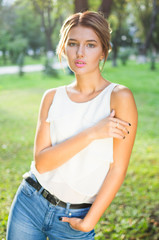 Fototapeta premium Bautiful girl wearing a white shirt poses in a city park
