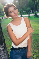 Bautiful girl wearing a white shirt poses in a city park