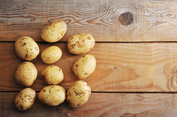 raw new potatoes in the skin on rustic wooden background