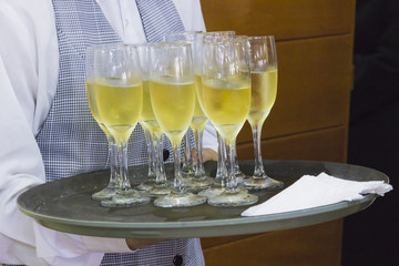 Champagne glasses. Waiter serving glasses of champagne.
