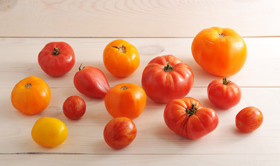 red and yellow tomatoes on wooden white background