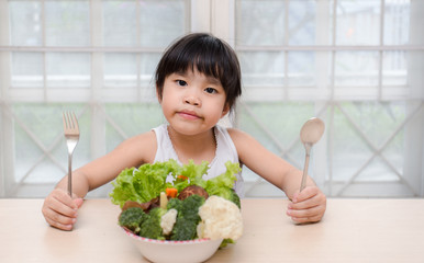 Little young cute sweet smiling girl eats fresh salad / healthy eating concept