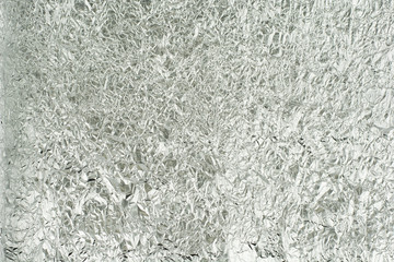 sheet of silver leaf background with shiny crumpled uneven surfa