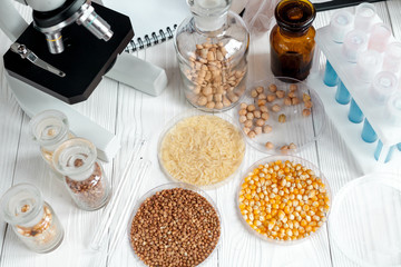 cereals in glass vials for analysis on wooden background