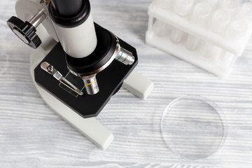 microscope in the laboratory with test tubes on wooden background