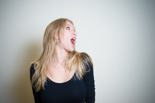 Astonished screaming young blonde woman portrait