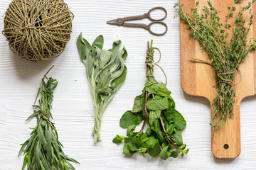fresh herbs preparation to be dried top view wooden background