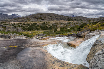 Beautiful mountain river with small cascades in the pristine wilderness of the Yukon in Canada during the beginning of the indian summer season