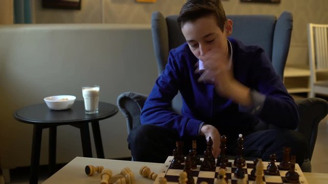 Teen boy plays chess