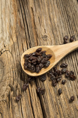 Closeup of Raisins in a wooden spoon on wood table