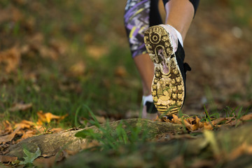 Woman feet in shoes on a forest path on sunset