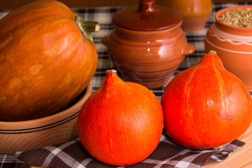 Big and small pumpkin and wooden utensils in rustic style