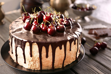 Delicious cake with cherry on table