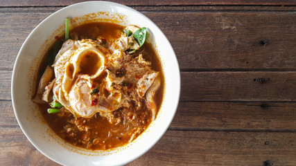 Hot and spicy noodle egg with soup on the wooden table 