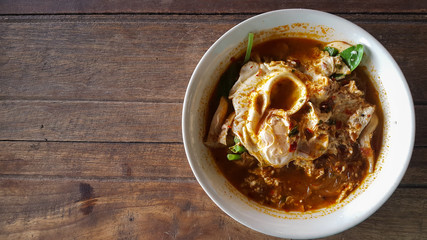 Hot and spicy noodle egg with soup on the wooden table 