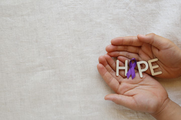 Hands holding HOPE with Purple ribbon, copy space background, Alzheimer's disease, Pancreatic...
