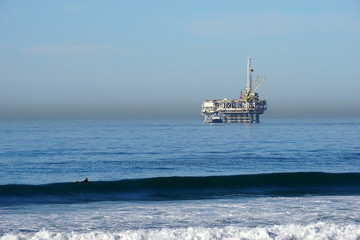oil platforms and surfers in pacific ocean