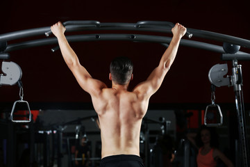Fototapeta na wymiar Athletic man training back muscles in gym