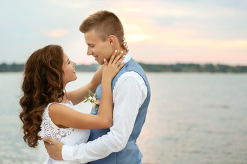 Portrait of beautiful wedding couple near river, close up view