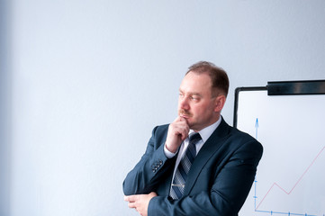 Man in a business suit stands in thought