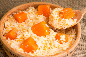 Pumpkin risotto in a wooden plate. Italian Cuisine.