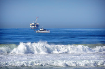 oil platform and fishing boat on ocean